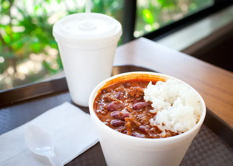 A bowl of Cafe 100 chili with kidney beans served beside white rice.